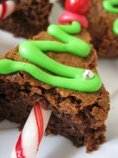 a white plate topped with brownies covered in green icing and candy canes