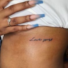 a woman's stomach with the word love you tattooed on it