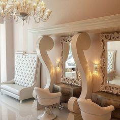 a room with chairs, mirrors and chandelier on the wall next to each other