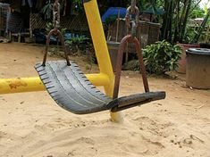 a yellow and black swing set in the sand