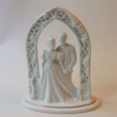 a white figurine with a man and woman holding each other