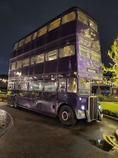 a double decker bus parked in front of a tree