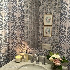 a white sink sitting under a bathroom mirror next to a wall mounted faucet