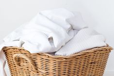 a wicker basket with white linens in it