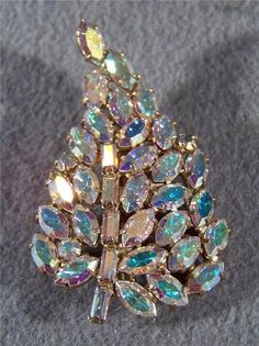 I am offering you this raised dimensional marquise and rectangle shaped emerald cut aurora borealis rhinestone pin brooch in multiple colors in a large leaf shape. It is totally encrusted with large intense aurora borealis rhinestones, a massive space of all sparkle. There are tons of stones, all prong set in this gorgeous setting. It is measures a very bold 2 inches by 1 1/4 inch. There is a secure safety locking closure pin back. It is in mint condition, and looks as though it was never worn! Costume Jewelery, Vintage Rhinestone, Vintage Costume Jewelry, Leaf Shapes, Vintage Jewellery, Aurora Borealis, Vintage Costumes, Pin Brooch, Rectangle Shape