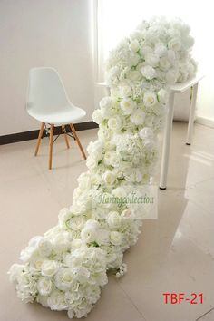 white flowers are arranged in the shape of a long ribbon on top of a chair