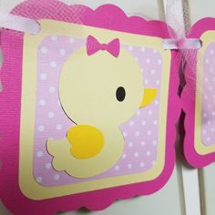 a pink and yellow ducky banner hanging from a wall