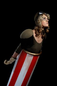 a woman dressed in an american flag costume and holding a large red white and blue object