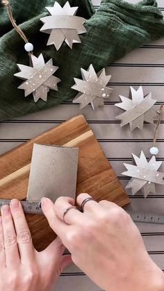 someone is cutting out some paper stars on a wooden board and measuring them with a ruler