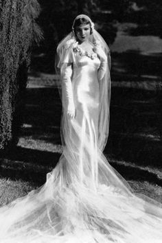 an old black and white photo of a woman in a wedding dress