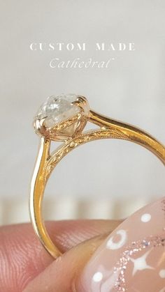 a close up of a person's hand holding a gold ring with a diamond on it