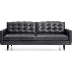 a black leather couch sitting on top of a white floor