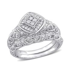 a white gold ring with diamonds on the sides and an intricate design in the center