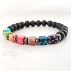 This beautiful and colorful Seven chakras bracelet is made with 8mm opaque onyx beads and 7 square of 7mm natural stone which are associated with the 7 chakras.  1-Crown chakra (Purple) 2-Third eye chakra (Indigo) 3-Throat chakra (Blue) 4-Heart chakra (Green) 5-Solar plexus chakra (Yellow) 6-Navel chakra (Orange) 7-Root chakra (Red) Bracelet Size: This bracelet is adjustable and comfortably fits a wrist between 7 to 8.5 inches. If you need a different size please contact me  before  ordering. Benefits of wearing the Chakra healing bracelet:  The chakra stones beaded bracelet take away your stress and help you to stay focused. The seven chakra stones help you to get spiritual awakening and balance your chakras. Positive vibrations of the stones restore balance among the chakras and replace Navel Chakra, Chakras Bracelet, The 7 Chakras, Red Bracelet, Seven Chakras, Yoga Bracelet, Red Bracelets, Solar Plexus Chakra, 7 Chakras