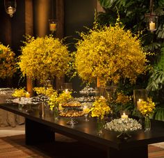 the table is covered with yellow flowers and candles