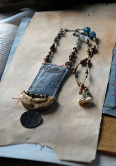 a necklace made out of old jeans and beads on top of a piece of paper