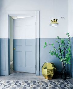 an image of a room with blue walls and yellow vases on the floor in front of it