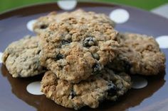 three oatmeal cookies sitting on top of a brown and white polka dot plate