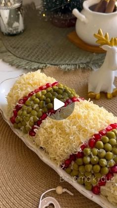 a plate with peas and cheese on it sitting on a table next to other dishes