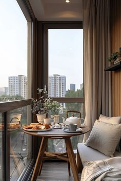 a small table with food on it in front of a large window overlooking the city