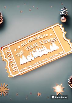 a gold ticket sitting on top of a table next to christmas ornaments and stars in the background