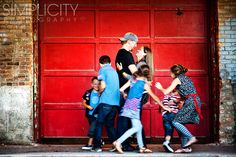 a group of people standing in front of a red door