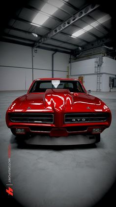 a red car parked in a garage with a heart on the hood