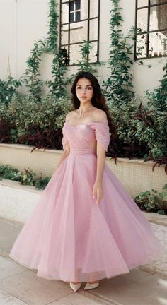 a woman in a pink dress posing for the camera