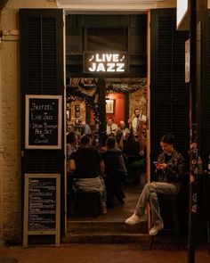 people sitting at tables in front of a jazz bar