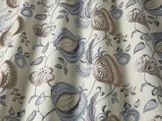 a close up view of a curtain with flowers and leaves on the fabric in grey