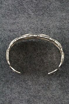 This sterling silver bracelet was made by Navajo silversmith Leander Tahe. The inside is signed L. Tahe and stamped sterling.Size: 6" (will fit up to a 7 1/4" wrist)Gap: 1 1/4"Width: 1 1/2"Free shipping on all orders! We ship with USPS and always include tracking. All orders ship within a day of payment.Returns are accepted up to 30 days after you receive your order. Just send us a message. Our shop offers cash back or store credit. The item must be returned in new condition. Silver Southwestern Style Bracelet With Oyster Clasp, Sterling Silver Oxidized Bangle Bracelet, Silver Southwestern Style Oyster Bracelet, Southwestern Style Silver Oyster Bracelet, Southwestern Silver Cuff Bracelet With Oyster Detail, Artisan Sterling Silver Bracelet With Oyster Detail, Artisan Sterling Silver Oyster Bracelet, Sterling Silver Bracelet, Native American Jewelry