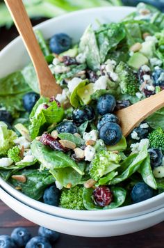 a salad with blueberries, broccoli and feta cheese in a bowl