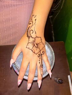 a woman's hand with a flower tattoo on it