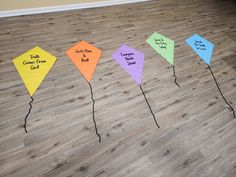 four kites with words written on them sitting on the floor next to each other