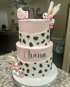 a three tiered cake decorated with pink and black polka dots, zebras, and hearts