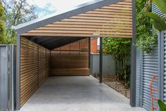 an outdoor covered parking lot with wood slats on the sides and metal fence around it