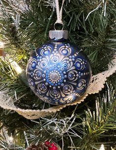 a blue and white ornament hanging from a christmas tree