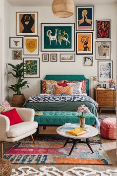 a bedroom with pictures on the wall and a bed in the middle, surrounded by colorful rugs