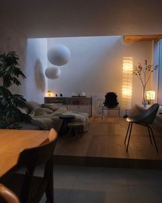 a living room filled with lots of furniture next to a wooden table and chair in front of a window