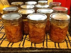 several jars filled with food sitting on top of a counter next to an orange and yellow towel