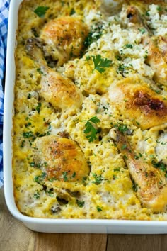 chicken and rice casserole with parsley in a white dish on a wooden table