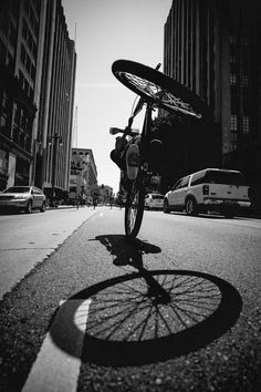 a bike parked on the side of a road next to tall buildings