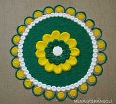 a green, yellow and white circular design on a table with pearls around the edges