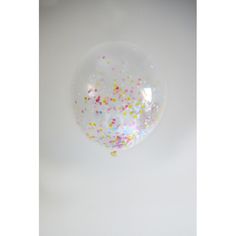 a clear bubble filled with confetti and sprinkles on a white background