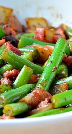 a white bowl filled with green beans and bacon