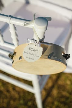 a close up of a white chair with a label attached to the armrests