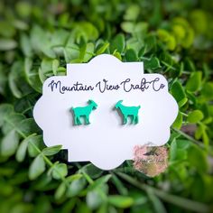 small green dog shaped earrings on top of a white sign that says mountain view craft co