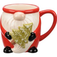 a red and white ceramic mug with a santa clause holding a christmas tree ornament