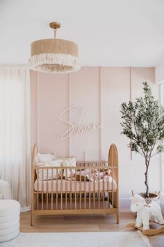 a baby's room with pink walls and white furniture, including a crib