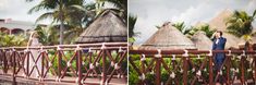 a bride and groom standing on a bridge in front of some thatched huts with palm trees